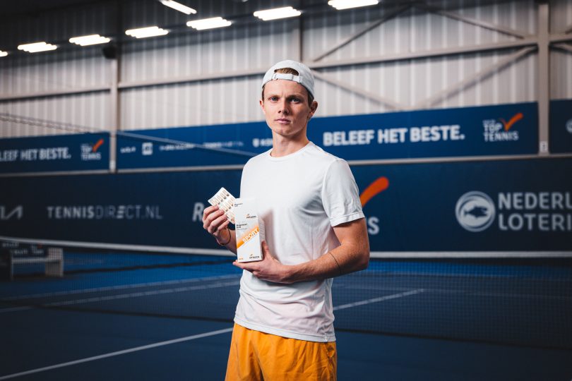 Tennisspeler op de tennisbaan met Magnesium Gold van Virtuoos in zijn handen.