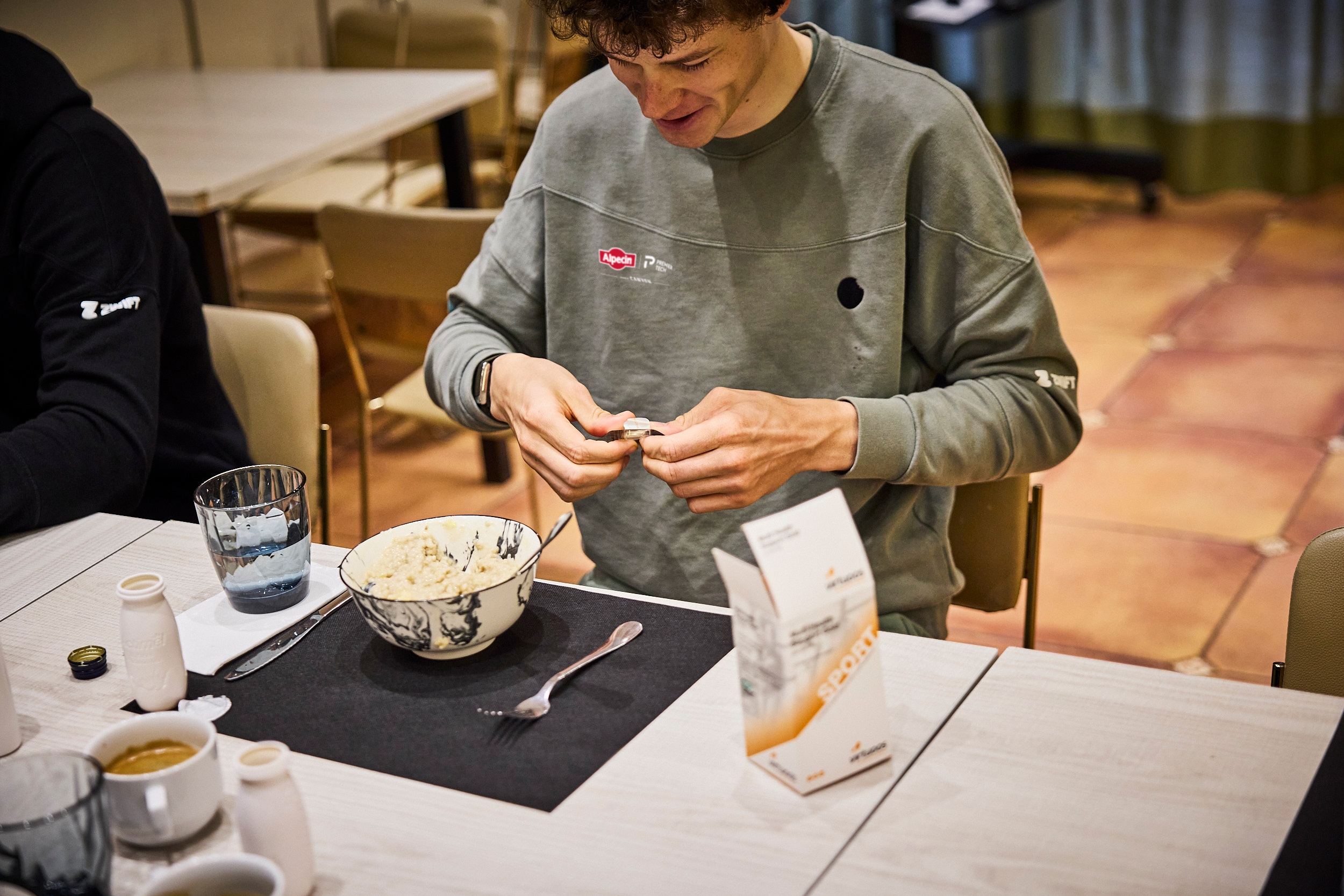 Renner van Alpecin-Premier Tech die een multivitamine neemt tijdens het ontbijt.