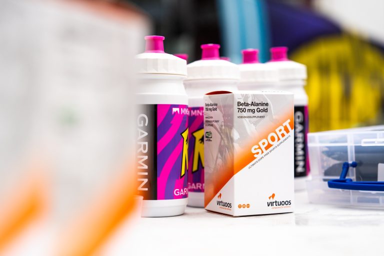 touring car bus unibet rose rockets met virtuoos beta alanine gold supplement op tafel naast andere prestatiesupplementen en bidons