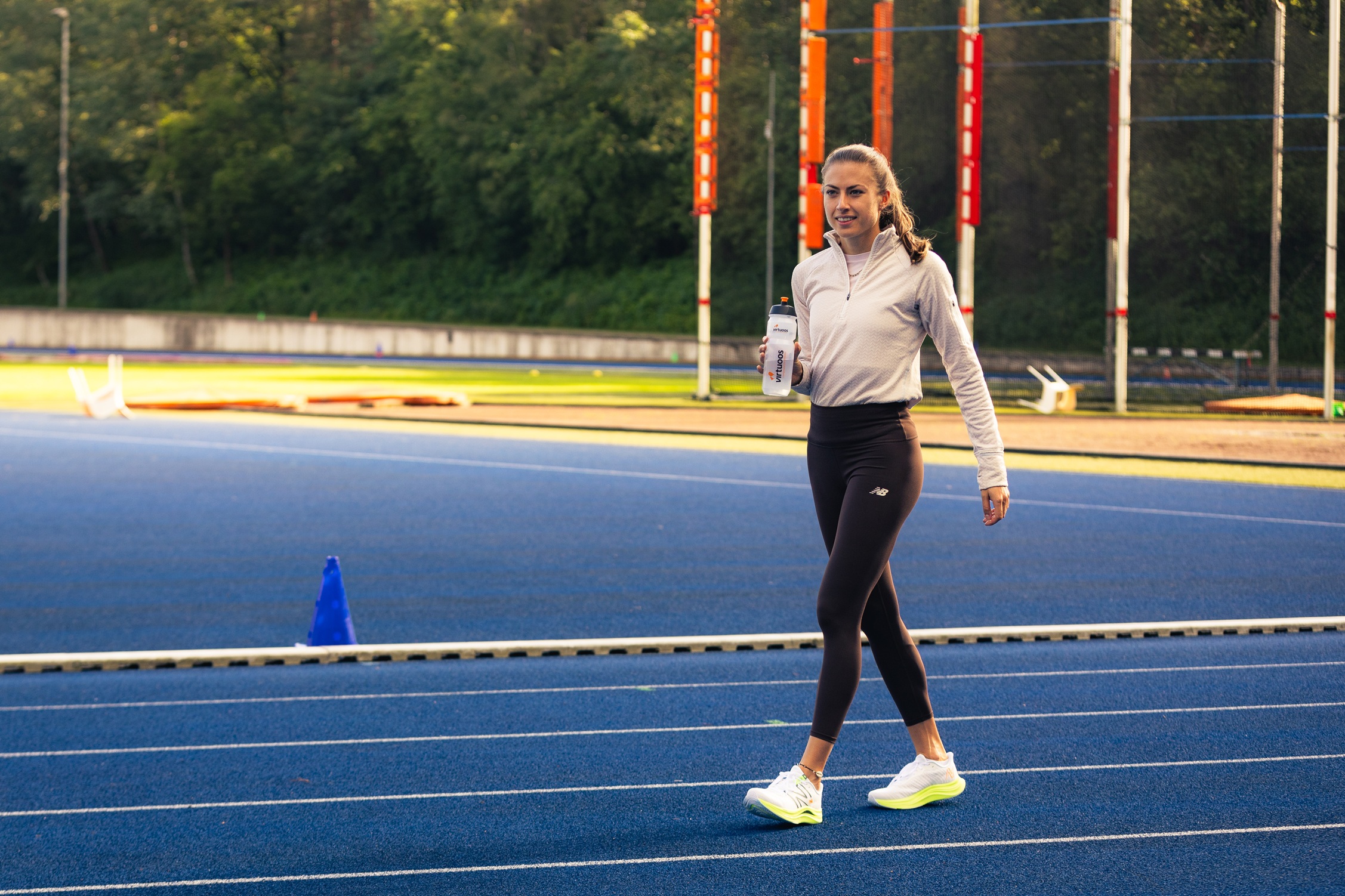 Atlete Eveline Saalberg op atletiekbaan met virtuoos bidon